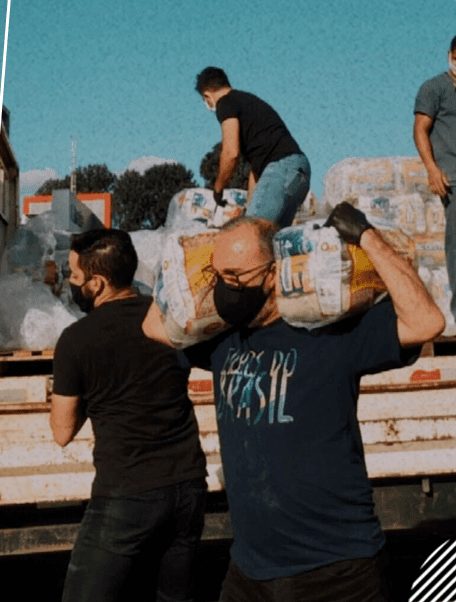 Voluntários do Filhos do Brasil descarregam um caminhão de cestas básicas numa Ação Social